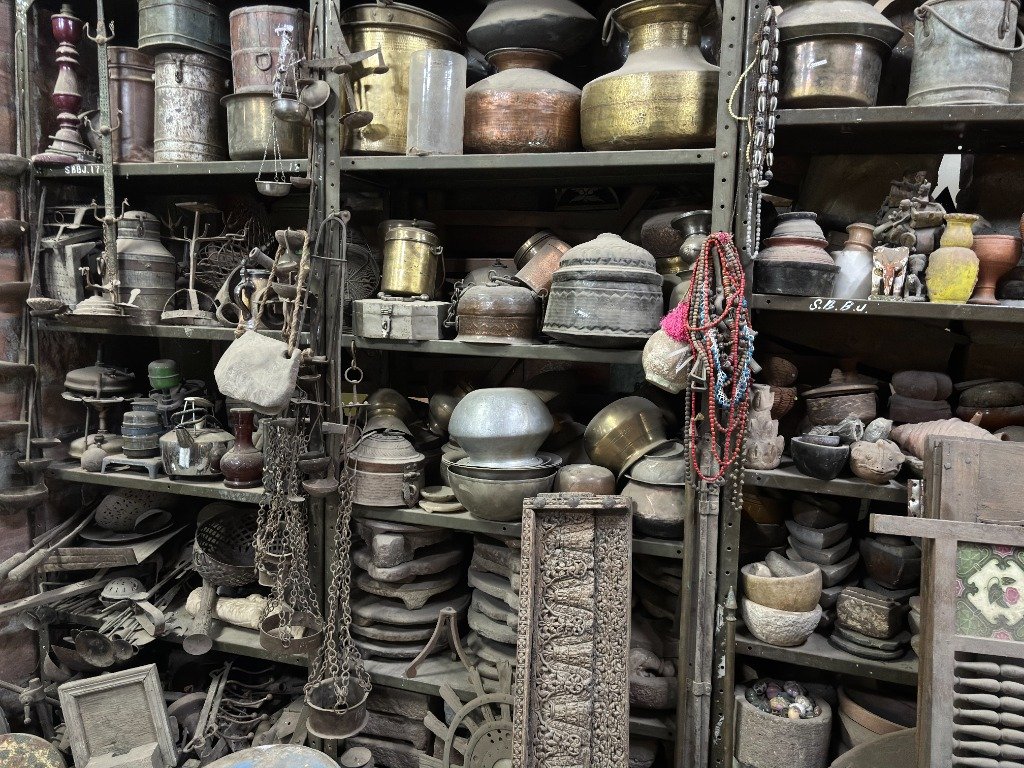 Authentic vintage Indian brass vessels, copper pots, hanging scales, and traditional handcrafted metalware in Rajasthan warehouse